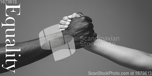 Image of African and caucasian hands gesturing on gray studio background, tolerance and equality concept