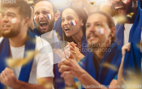 Image of Francian football, soccer fans cheering their team with a blue scarfs at stadium. Excited fans cheering a goal, supporting favourite players