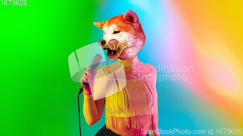 Image of Talented dog, professional musician performing on multicoloted background in neon light. Concept of music, hobby, festival, contemporary art collage. Modern design.