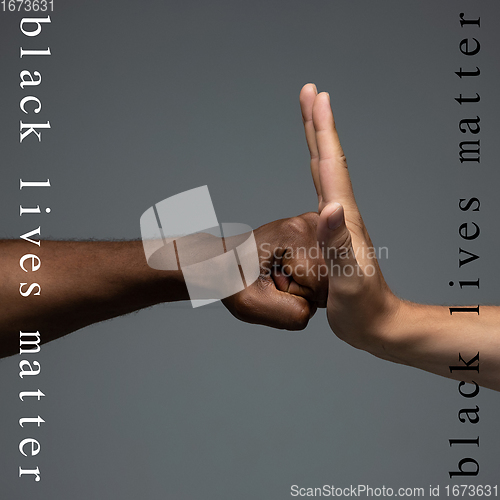 Image of African and caucasian hands gesturing on gray studio background, tolerance and equality concept