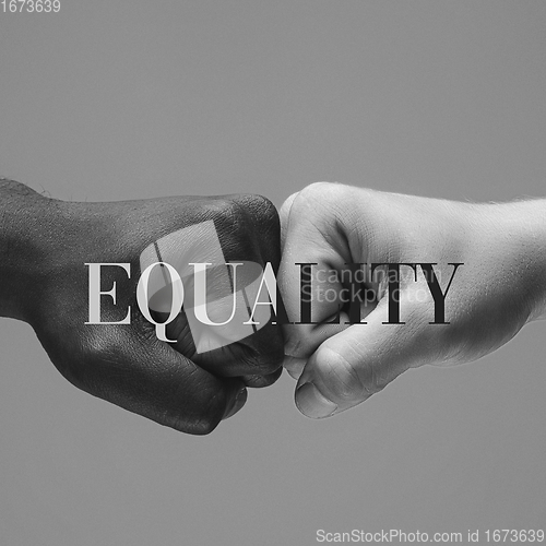 Image of African and caucasian hands gesturing on gray studio background, tolerance and equality concept