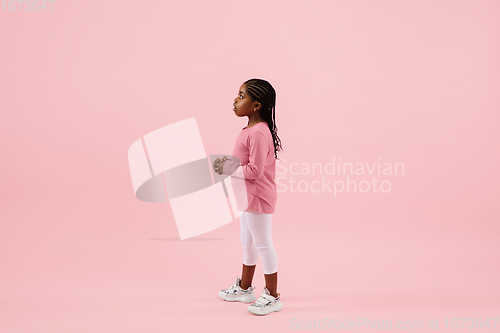 Image of Childhood and dream about big and famous future. Pretty little girl isolated on coral pink background