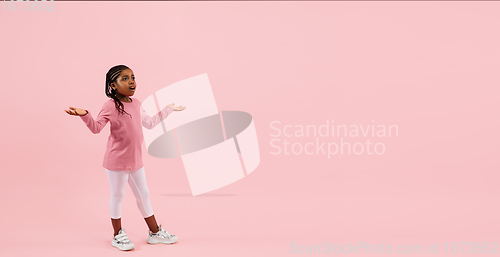 Image of Childhood and dream about big and famous future. Pretty little girl isolated on coral pink background