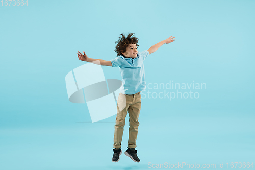 Image of Childhood and dream about big and famous future. Pretty little boy isolated on blue background