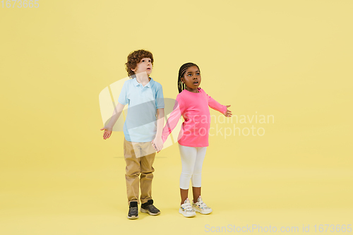 Image of Childhood and dream about big and famous future. Pretty little kids isolated on yellow background