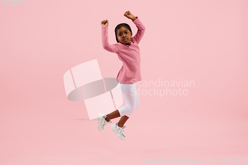 Image of Childhood and dream about big and famous future. Pretty little girl isolated on coral pink background