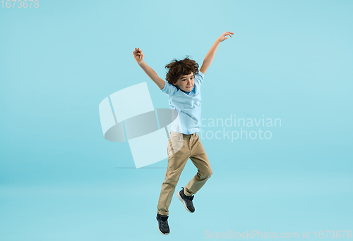 Image of Childhood and dream about big and famous future. Pretty little boy isolated on blue background