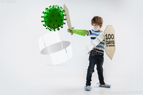 Image of Little caucasian boy as a warrior in fight with coronavirus pandemic, with a shield, a sword and a toilet paper bandoleer.