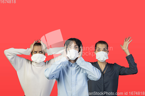 Image of People in protective face masks isolated on red studio background. New rules of COVID spreading prevention