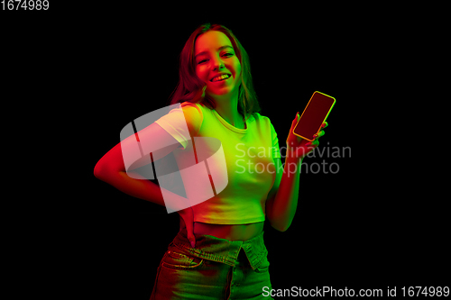 Image of Caucasian woman\'s portrait isolated on black studio background in multicolored neon light