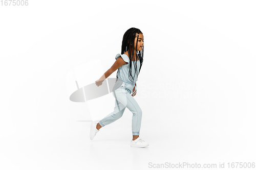 Image of Happy longhair brunette little girl isolated on white studio background. Looks happy, cheerful, sincere. Copyspace. Childhood, education, emotions concept