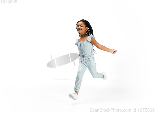 Image of Happy longhair brunette little girl isolated on white studio background. Looks happy, cheerful, sincere. Copyspace. Childhood, education, emotions concept