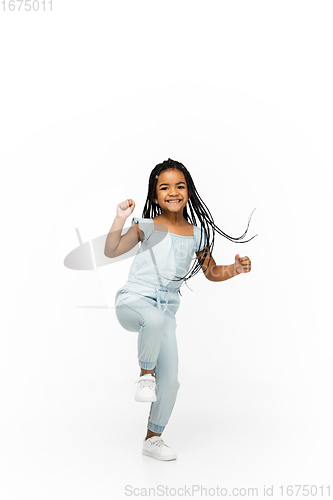 Image of Happy longhair brunette little girl isolated on white studio background. Looks happy, cheerful, sincere. Copyspace. Childhood, education, emotions concept