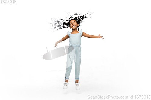 Image of Happy longhair brunette little girl isolated on white studio background. Looks happy, cheerful, sincere. Copyspace. Childhood, education, emotions concept