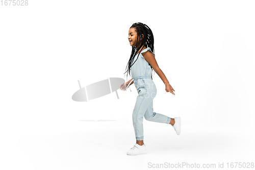 Image of Happy longhair brunette little girl isolated on white studio background. Looks happy, cheerful, sincere. Copyspace. Childhood, education, emotions concept