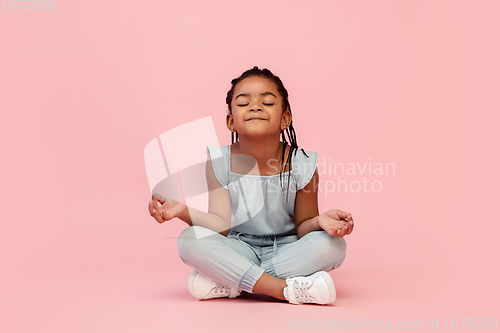 Image of Happy longhair brunette little girl isolated on pink studio background. Looks happy, cheerful, sincere. Copyspace. Childhood, education, emotions concept