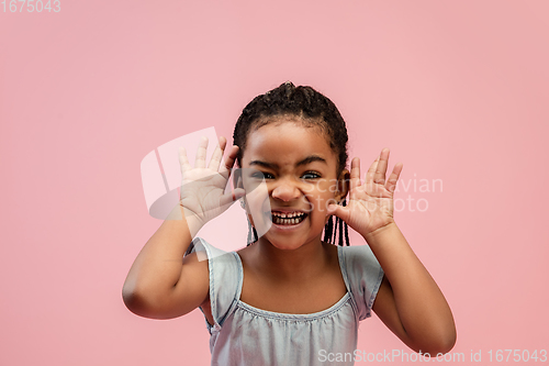 Image of Happy longhair brunette little girl isolated on pink studio background. Looks happy, cheerful, sincere. Copyspace. Childhood, education, emotions concept