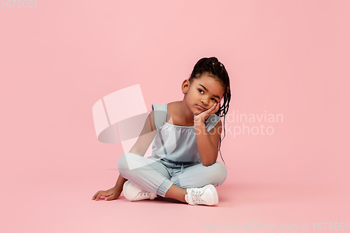 Image of Happy longhair brunette little girl isolated on pink studio background. Looks happy, cheerful, sincere. Copyspace. Childhood, education, emotions concept