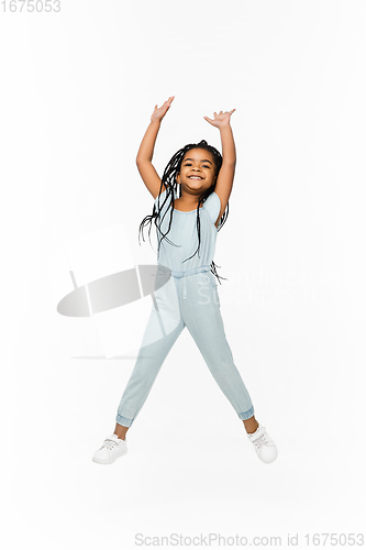 Image of Happy longhair brunette little girl isolated on white studio background. Looks happy, cheerful, sincere. Copyspace. Childhood, education, emotions concept