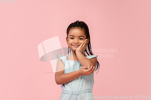 Image of Happy longhair brunette little girl isolated on pink studio background. Looks happy, cheerful, sincere. Copyspace. Childhood, education, emotions concept