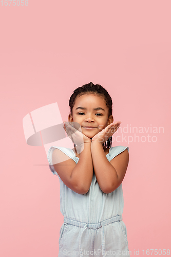 Image of Happy longhair brunette little girl isolated on pink studio background. Looks happy, cheerful, sincere. Copyspace. Childhood, education, emotions concept