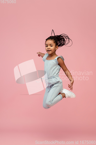 Image of Happy longhair brunette little girl isolated on pink studio background. Looks happy, cheerful, sincere. Copyspace. Childhood, education, emotions concept