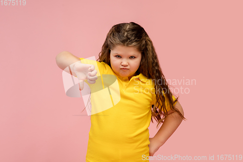 Image of Happy caucasian little girl isolated on studio background. Looks happy, cheerful, sincere. Copyspace. Childhood, education, emotions concept