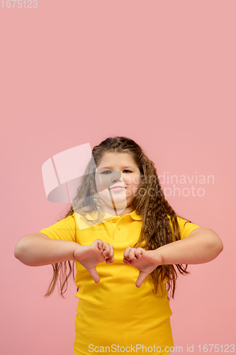 Image of Happy caucasian little girl isolated on studio background. Looks happy, cheerful, sincere. Copyspace. Childhood, education, emotions concept