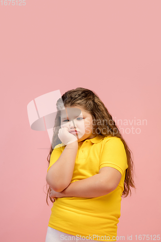 Image of Happy caucasian little girl isolated on studio background. Looks happy, cheerful, sincere. Copyspace. Childhood, education, emotions concept