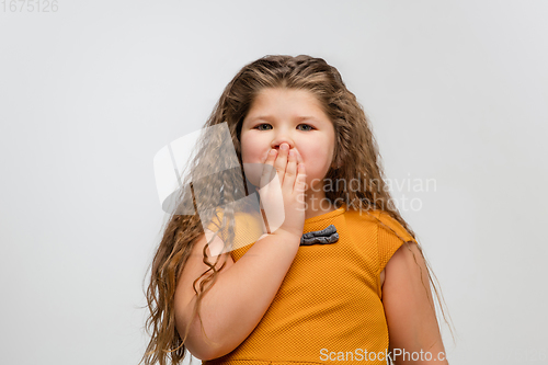 Image of Happy caucasian little girl isolated on studio background. Looks happy, cheerful, sincere. Copyspace. Childhood, education, emotions concept