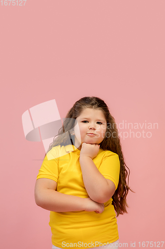 Image of Happy caucasian little girl isolated on studio background. Looks happy, cheerful, sincere. Copyspace. Childhood, education, emotions concept