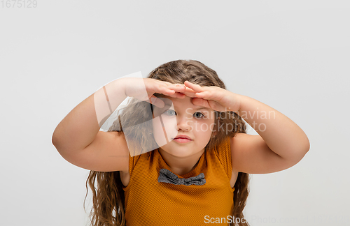 Image of Happy caucasian little girl isolated on studio background. Looks happy, cheerful, sincere. Copyspace. Childhood, education, emotions concept