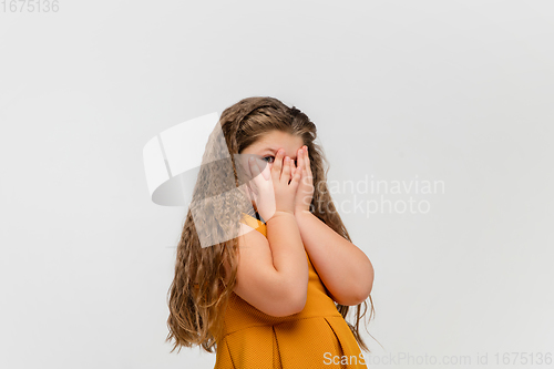 Image of Happy caucasian little girl isolated on studio background. Looks happy, cheerful, sincere. Copyspace. Childhood, education, emotions concept