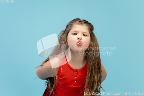 Image of Happy caucasian little girl isolated on studio background. Looks happy, cheerful, sincere. Copyspace. Childhood, education, emotions concept