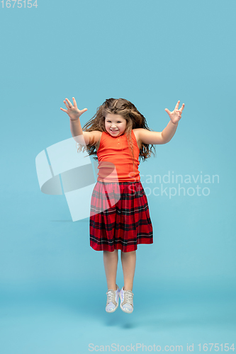 Image of Happy caucasian little girl isolated on studio background. Looks happy, cheerful, sincere. Copyspace. Childhood, education, emotions concept