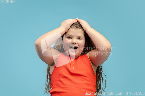 Image of Happy caucasian little girl isolated on studio background. Looks happy, cheerful, sincere. Copyspace. Childhood, education, emotions concept