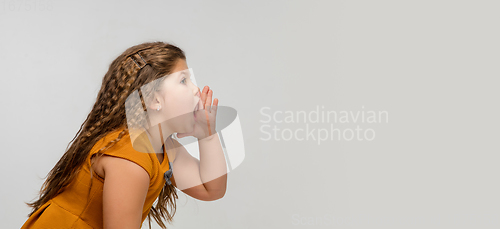 Image of Happy caucasian little girl isolated on studio background. Looks happy, cheerful, sincere. Copyspace. Childhood, education, emotions concept