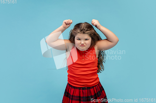 Image of Happy caucasian little girl isolated on studio background. Looks happy, cheerful, sincere. Copyspace. Childhood, education, emotions concept