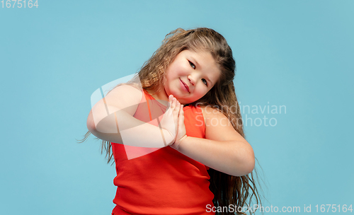 Image of Happy caucasian little girl isolated on studio background. Looks happy, cheerful, sincere. Copyspace. Childhood, education, emotions concept