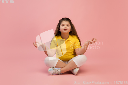 Image of Happy caucasian little girl isolated on studio background. Looks happy, cheerful, sincere. Copyspace. Childhood, education, emotions concept