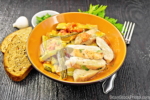 Image of Chicken with stewed zucchini in plate on dark board