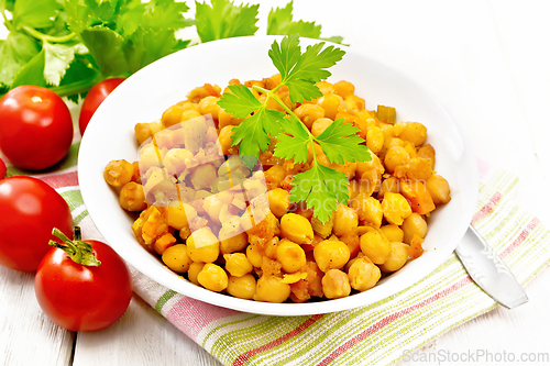 Image of Chickpeas stewed with vegetables in plate on board