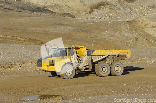 Image of Yellow dump truck working in gravel pit