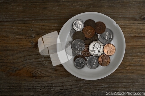 Image of small American coins on a white porcelain saucer 