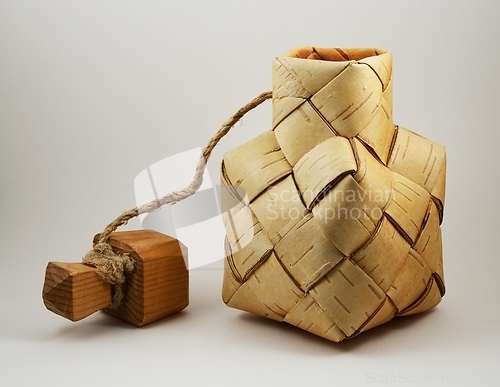 Image of a traditional salt container woven from birch bark with a wooden