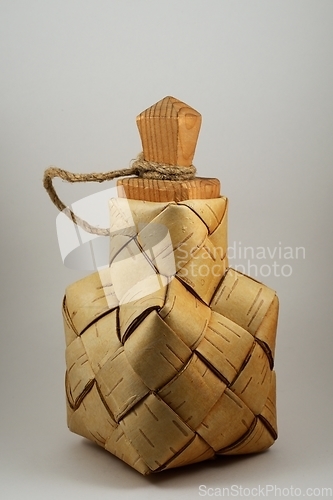 Image of a traditional salt container woven from birch bark with a wooden