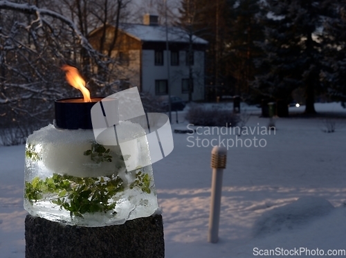 Image of a lit outdoor garden candle in the courtyard on Christmas