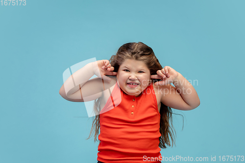 Image of Happy caucasian little girl isolated on studio background. Looks happy, cheerful, sincere. Copyspace. Childhood, education, emotions concept