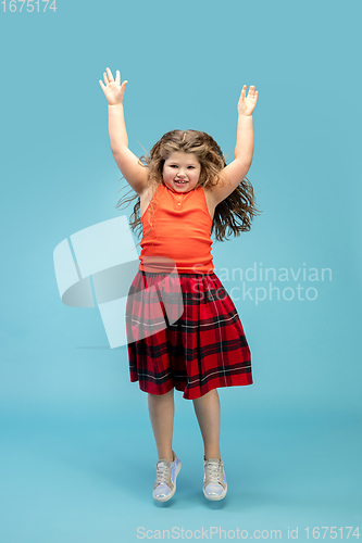 Image of Happy caucasian little girl isolated on studio background. Looks happy, cheerful, sincere. Copyspace. Childhood, education, emotions concept