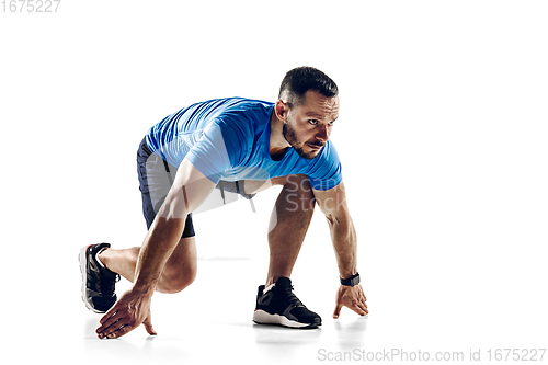 Image of Caucasian professional male runner, athlete training isolated on white studio background. Copyspace for ad.